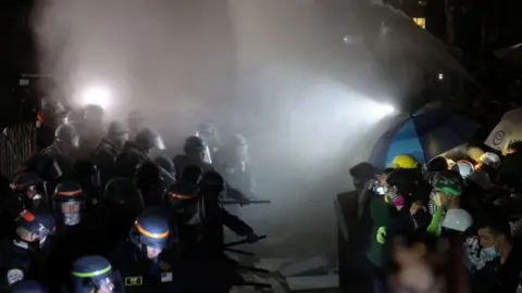 Getty Images Police officers clash with pro-Palestinian protesters as a fire extinguisher is deployed at UCLA early Thursday morning