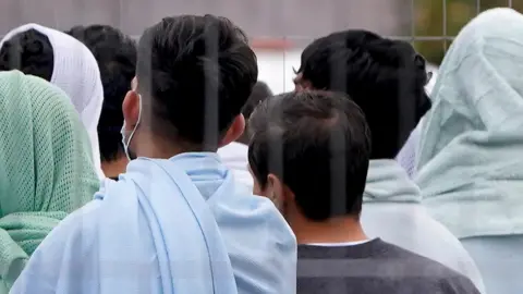 PA Media People thought to be migrants inside the Manston immigration holding centre in Kent