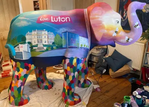 Sarah Harrison Sunrise a painted elephant being painted in a lounge