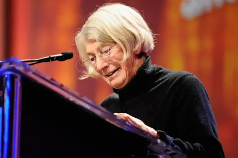 Getty Images Poet Mary Oliver speaks from a lectern, pictured in October 2010 in Long Beach, California
