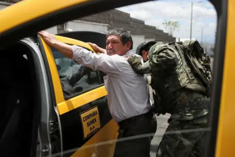 Henry Romero / Reuters A soldier inspects a car and his driver