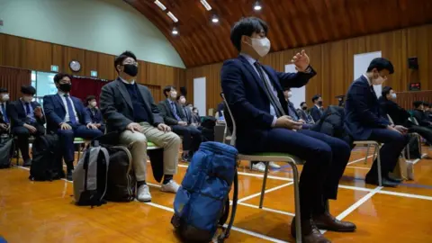 Getty Images South Korean Jehovah's Witnesses who are conscientious objectors to mandatory military service, await an induction session at a correctional facility where they will begin training as administrators, in Daejeon on October 26, 2020