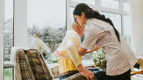 Getty Images Care giver and elderly person