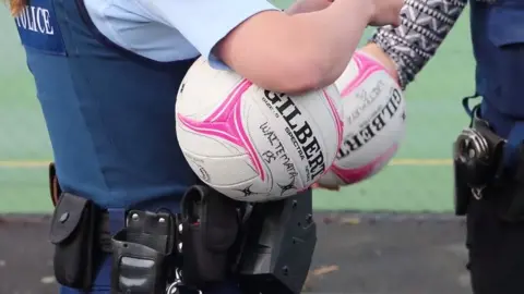 Waitemata Police A police officer holding a netball ball