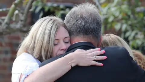 PA Media Pc Harper's relatives hug each other