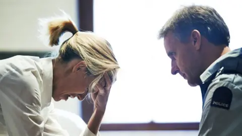 Getty Images Police comforts woman