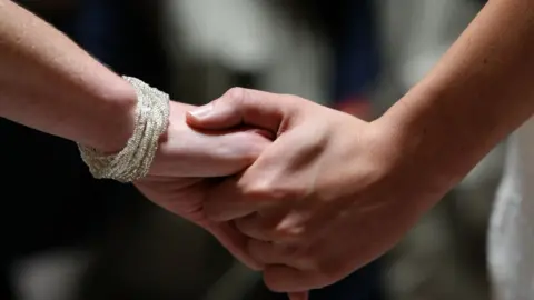 Getty Images Women holding hands