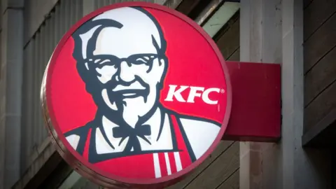 The sun shines on the logo of Colonel Sanders, founder of the Kentucky Fried Chicken fast food restaurant KFC, on October 18, 2023 in Bath, England.