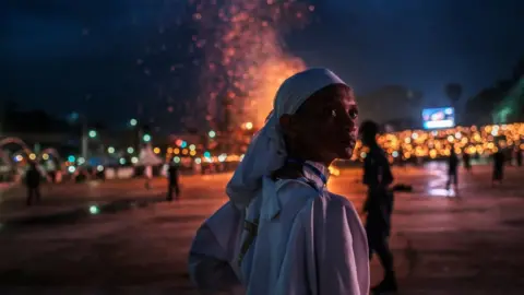 AFP Person standing in front of bonfire