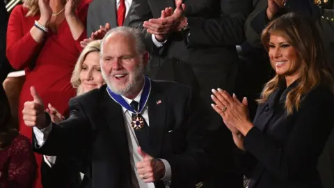 MANDEL NGAN/Getty Images Rush Limbaugh pumps thumb after being awarded the Medal of Freedom by First Lady Melania Trump