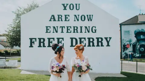 Holly and Lime Photography Danielle Doherty and Emma Bradley standing outside Free Derry corner