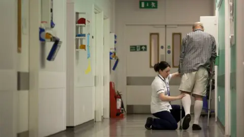 Getty Images A nurse tending to a patient in a hospital