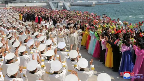 Reuters People attend what North Korean state media report was the country's launching ceremony for a new tactical nuclear attack submarine