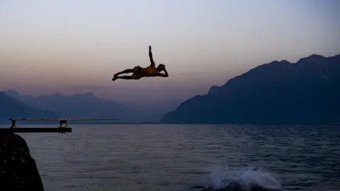 EPA People cool down at sunset in Lake Geneva - 26 June