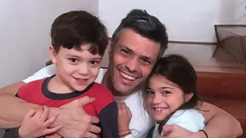 AFP Venezuelan opposition leader Leopoldo Lopez hugging his children at his house in Caracas after his release from prison (08 July 2017)