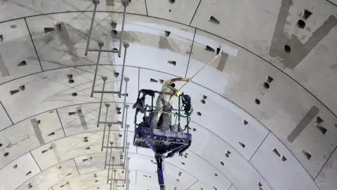 EPA A laborer paints the walls of one of the new tunnels under the Suez Canal, in Ismailia, 120km east of Cairo, Egypt, 04 September 2018