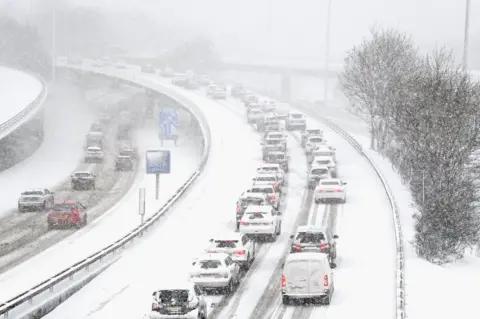 Getty Images Vehicles drive through snow on the M8 in Glasgow