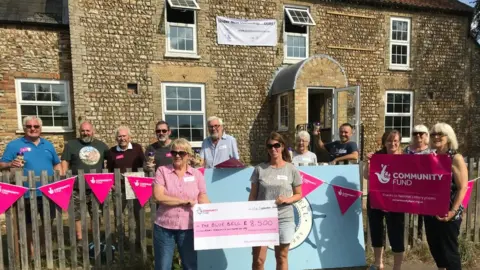 Shareholders and volunteers outside the Blue Bell pub, Stoke Ferry, Norfolk