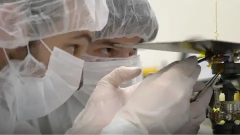 NASA/JPL-CALTECH The Wright Brothers fabric is taped just under Ingenuity's solar panel