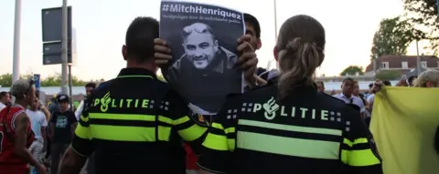 Getty Images Protester holds up placard of Aruba-born Mitch Henriquez who died in June 2015