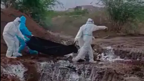 India coronavirus: Officials sorry after video shows bodies flung into pit