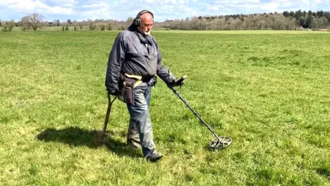 Mimzy with metal detector in field