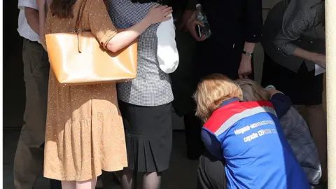 Getty Images A medical worker comforts relatives of students of School No 175 in Kazan, 11 May