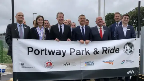 BBC Group of people holding up a sign that says Portway Park & Ride