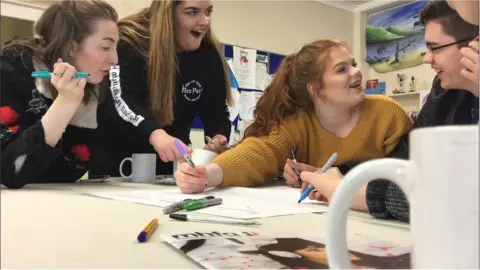 Ewanrigg Local Trust Four young people talking around a table