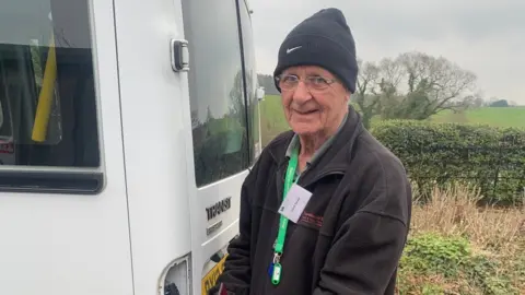 CHSW Dae Senior standing by a white van at Children's Hospice South West at Wraxall