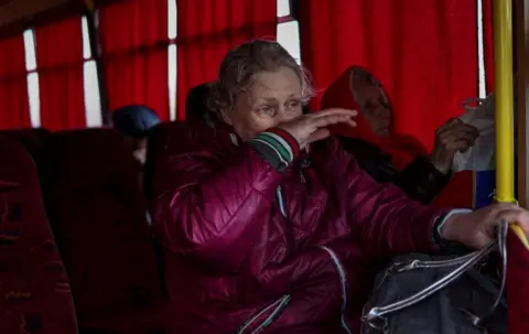 Ronaldo Schmidt / AFP A woman cries after boarding a bus to leave Severodonetsk, in eastern Ukraine