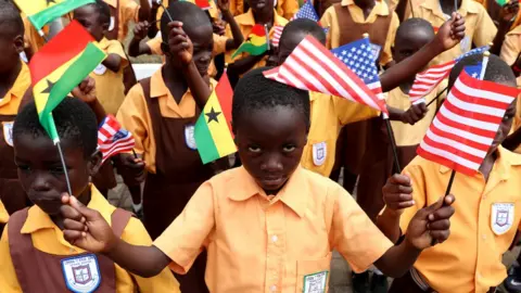 Reuters Children carry flags as they greet U.S. first lady Melania Trump on arrival in Accra