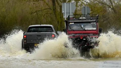 PA Media Cars driving through a flooded road