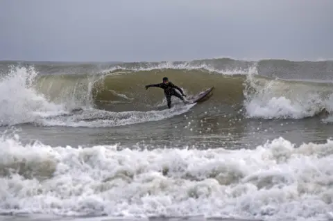 Shutterstock Surfers at Langland Bay, near Swansea, 14 January 2021