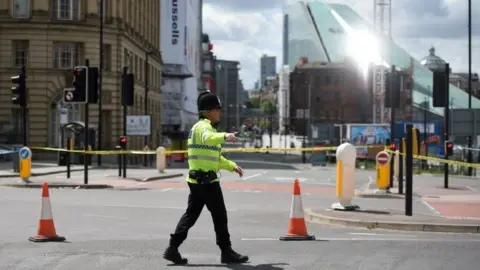 AFP/Getty Images A police officer patrols a cordon near to the Manchester Arena