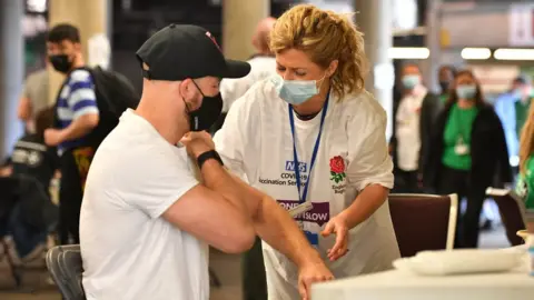 PA Media A man getting his vaccination at Twickenham stadium