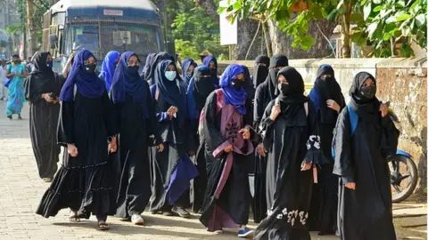 Getty Images Students of government Pre-University college in Kundapur town wearing hijab arrive at their college in Udupi district in Karnataka state on February 7, 2022.