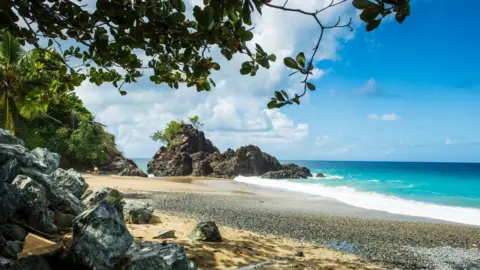 Getty Images A general view of Turtle Beach, Tobago (also known as Courland Bay) showing sand, rocks, blue sea and sky