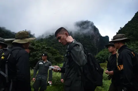 AFP Thai soldiers and police gather in the mountains near the Tham Luang cave