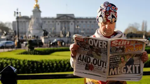 AFP Man reading the Sun newspaper outside Buckingham Palace
