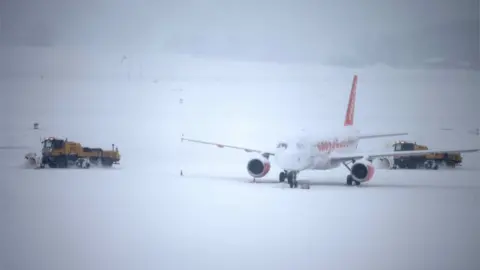 Reuters Snow plough removes snow next to an EasyJet aircraft during a temporary closure at Cointrin airport in Geneva, Switzerland, 1 March 2018