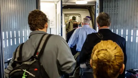 Getty Images Passengers boarding a flight.