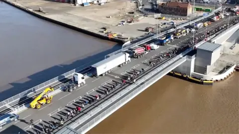 A convoy of vehicles driving over Herring Bridge in Great Yarmouth to mark its official opening.