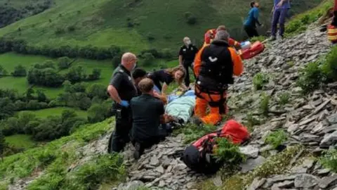 rescuers saving man on hillside