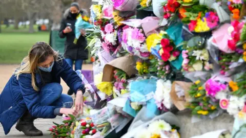 Reuters A woman lays flowers at the memorial site