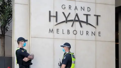 Getty Images Police guard quarantining tennis players inside the Grand Hyatt Melbourne in Australia