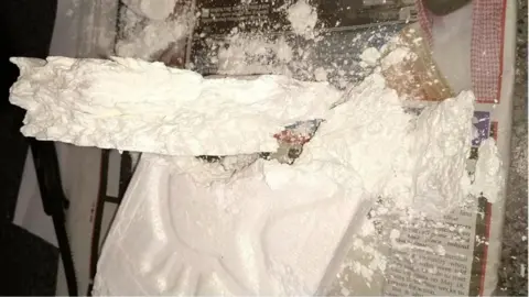 Met Police Image showing a large crumbled block of cocaine on a newspaper