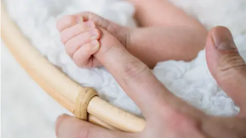 Getty Images Baby clasps mum's finger