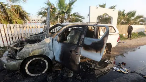 Reuters A burned out vehicle in Gaza