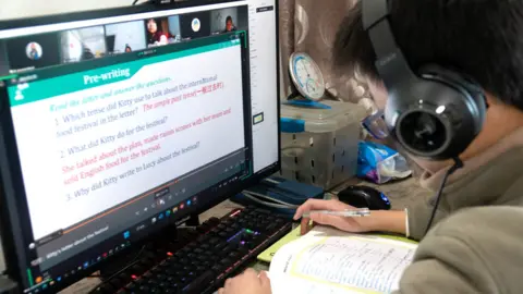 A student attends an English class at home in front of his computer in Shanghai, China, on 19 December 2022